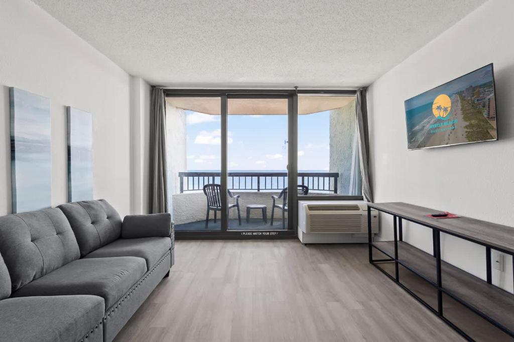 ein Wohnzimmer mit einer Couch und einem Tisch in der Unterkunft Compass Cove 759 - Oceanfront in Myrtle Beach