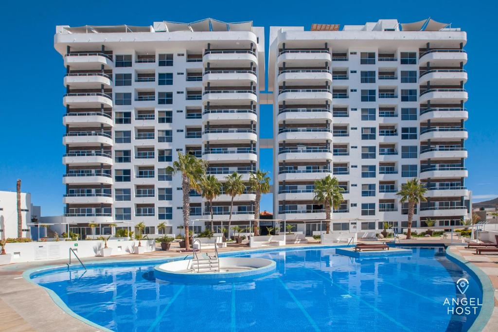 een zwembad voor een groot appartementencomplex bij Stylish Condo with Pools Gym Sunset Bay Views in La Paz