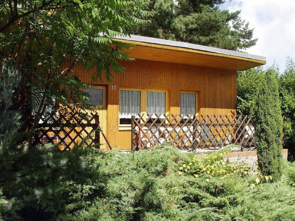 a small house with a fence in front of it at Feriensiedlung Am Grundlossee in Sewekow in Sewekow