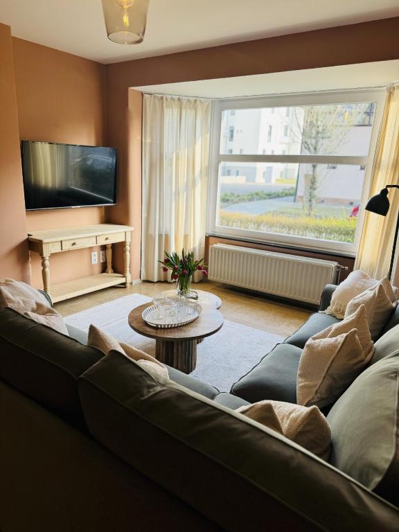 a living room with a couch and a tv at Two bedroom apartment 150m from the beach in De Haan