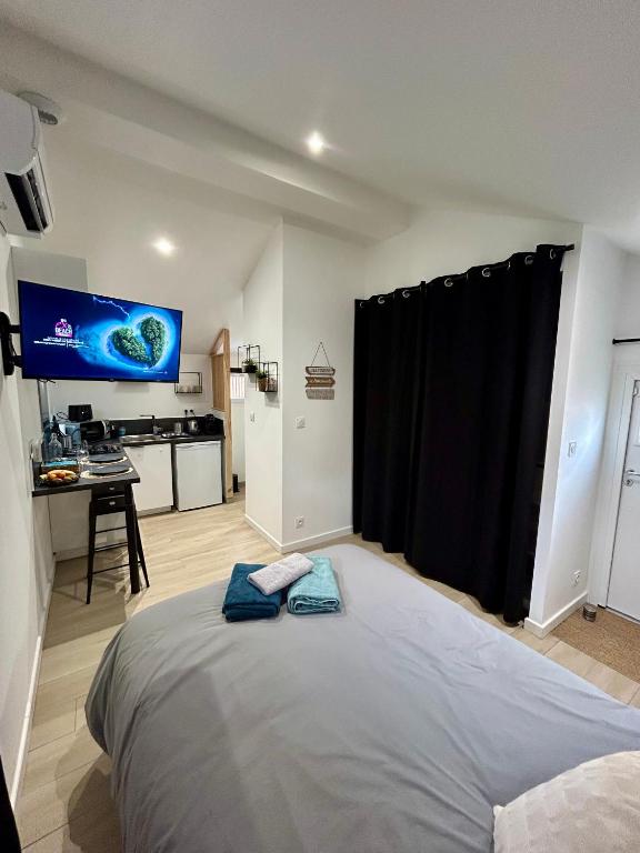 une chambre avec un grand lit et une cuisine dans l'établissement Tiny house de charme toute équipée, à Le Pian-Médoc