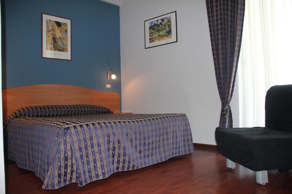 - une chambre avec un lit et une chaise dans l'établissement B&B Luna Blu, à Modica