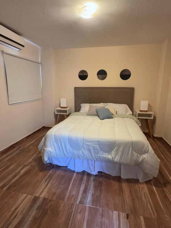 ein Schlafzimmer mit einem großen Bett mit zwei Lampen an der Wand in der Unterkunft Africa Suites in Cordoba