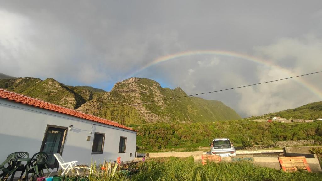 a rainbow over a mountain with a car and a house at Casa do Branco in Faja Grande