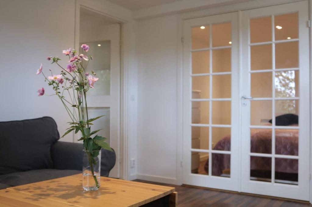 a vase with flowers on a table in a living room at New apartment, parking, close to city and nature in Stockholm