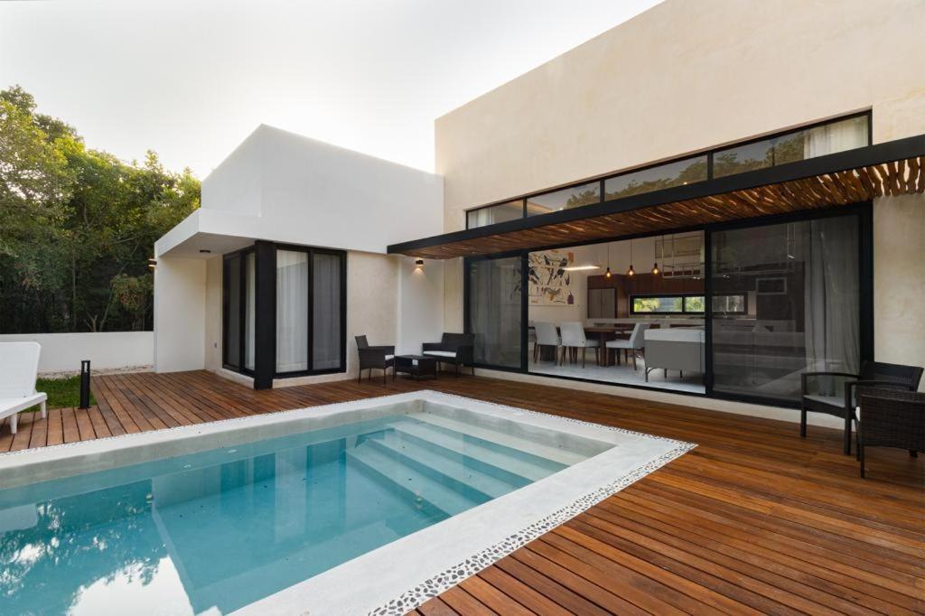 a house with a swimming pool on a wooden deck at ¡Increible! Villa Luz de Luna in Akumal