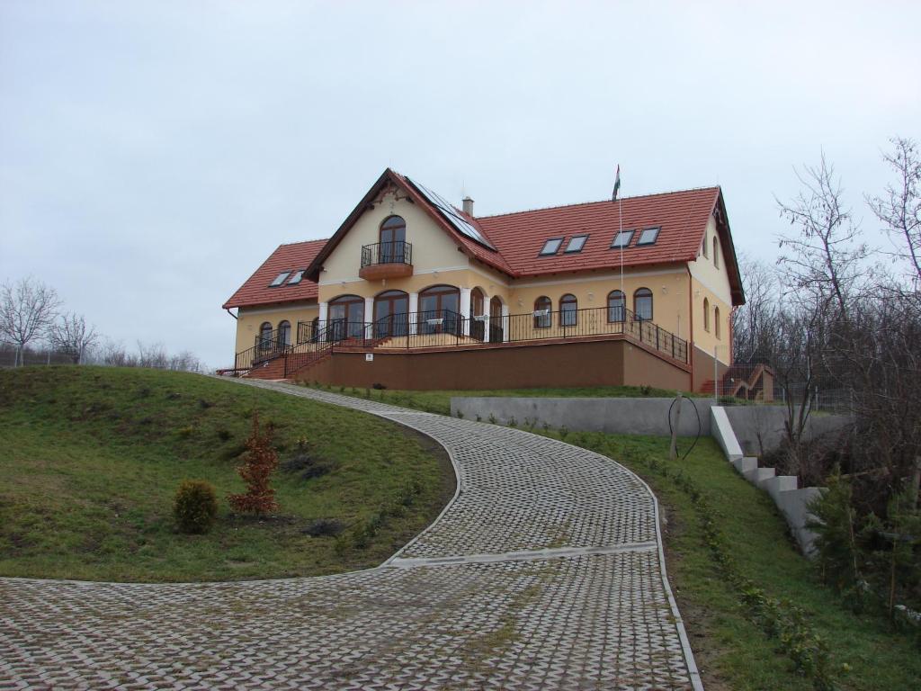 uma casa no topo de uma colina com uma entrada em Berezdtető Vendégház em Cserépfalu