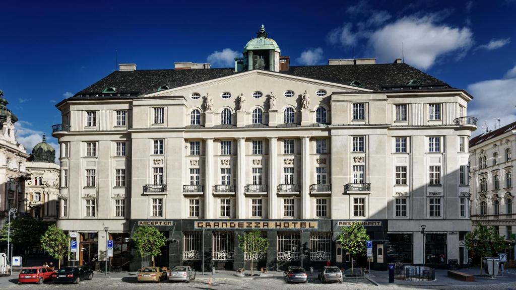 un gran edificio blanco con un cartel. en Grandezza Hotel Luxury Palace en Brno