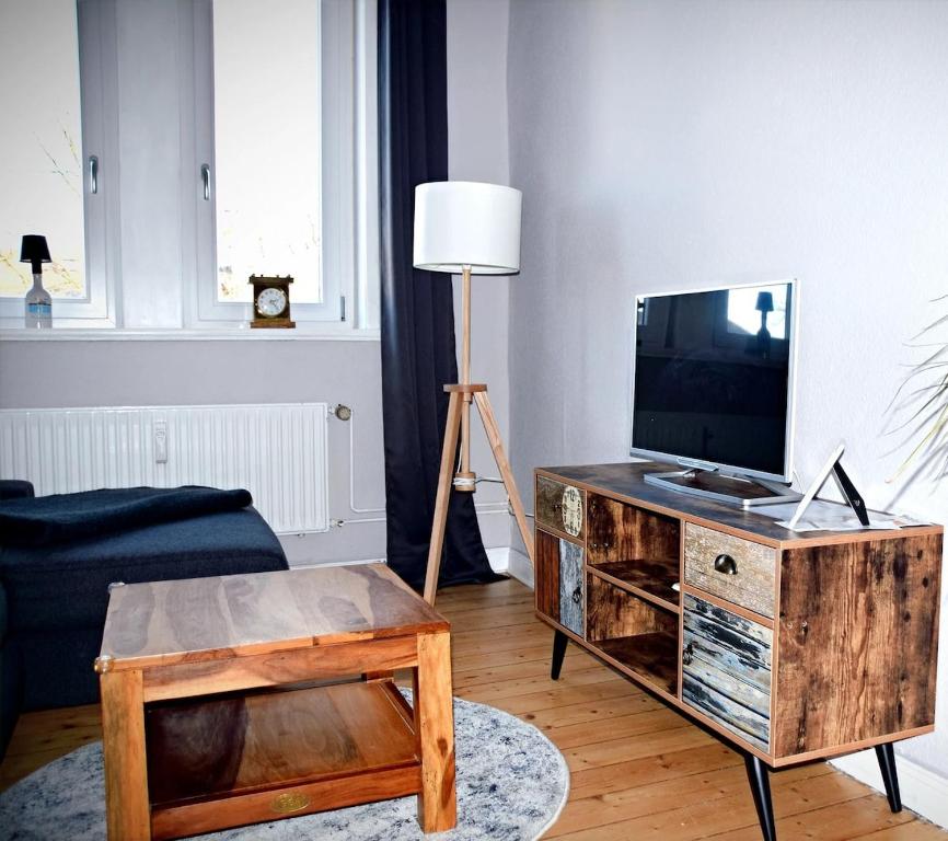 a living room with a television on a wooden table at Lüner Apartment in Lüneburg