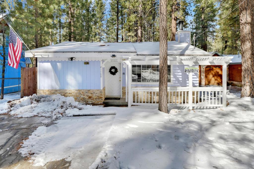 ein weißes Haus mit einem Zaun im Schnee in der Unterkunft Cozy summit #2222 in Big Bear Lake