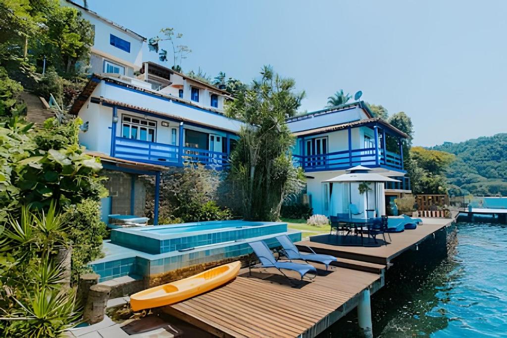 una casa con piscina accanto all'acqua di Casarão dos Pereira - Acesso a Praia da Figueira ad Angra dos Reis