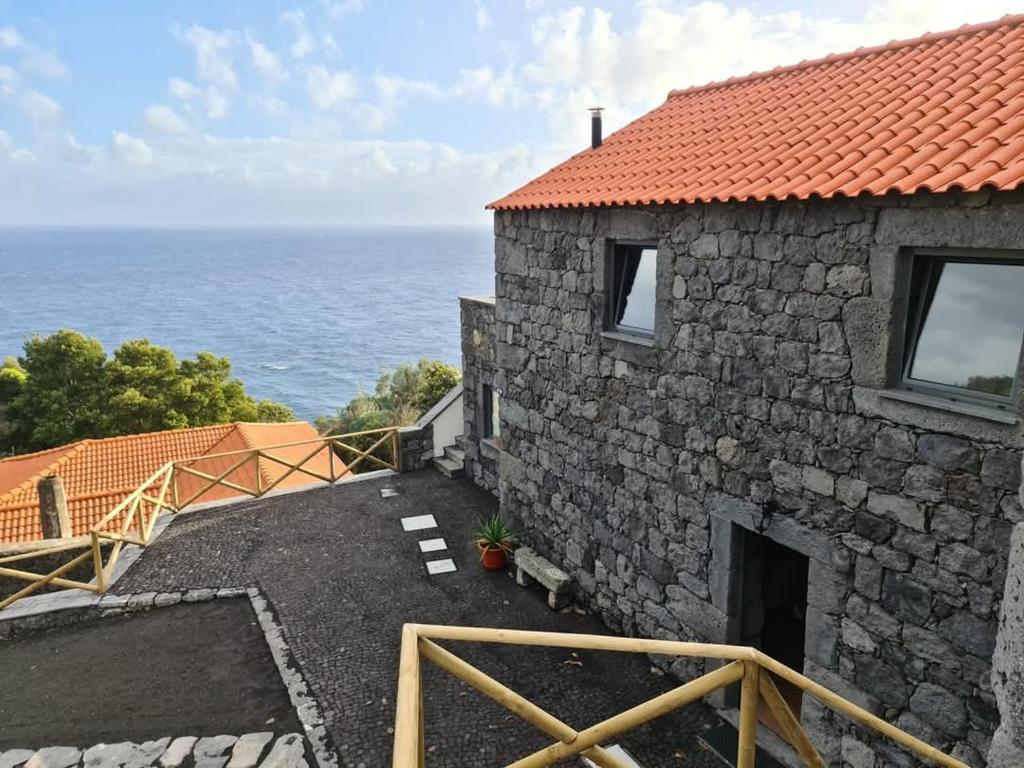 a stone house with a view of the ocean at Quinta do Caminho do Caminho da Igreja, Turismo em Espaço Rural in Manadas