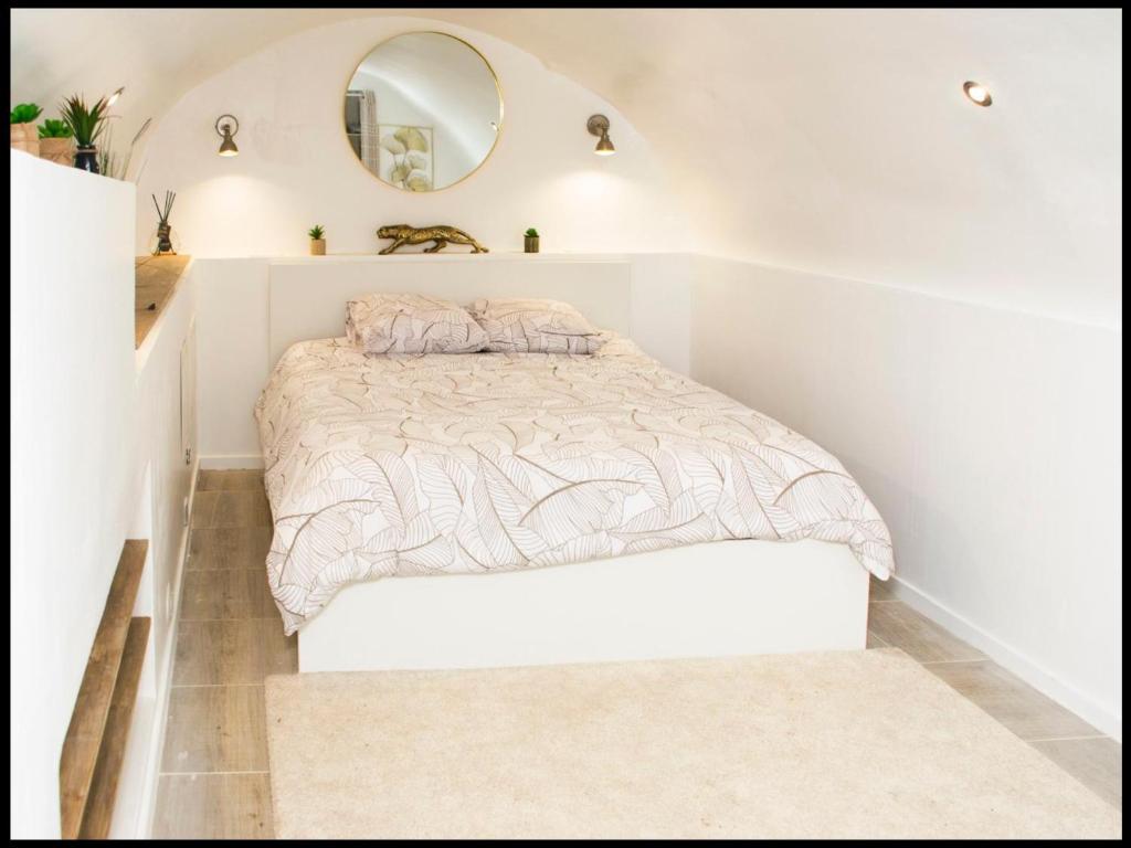 une chambre avec un lit et un miroir dans l'établissement La Calade Enchantée pour 4, à Marseille