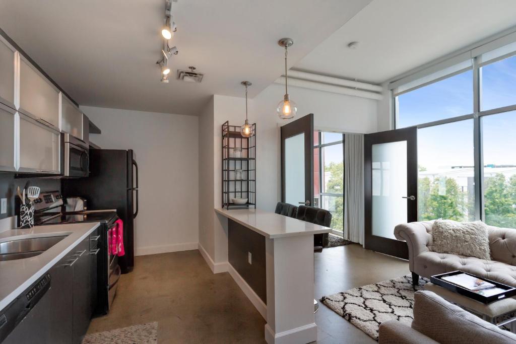 a kitchen and living room with a couch and a table at 5M307- Elegant Condo with Rooftop Deck in Nashville