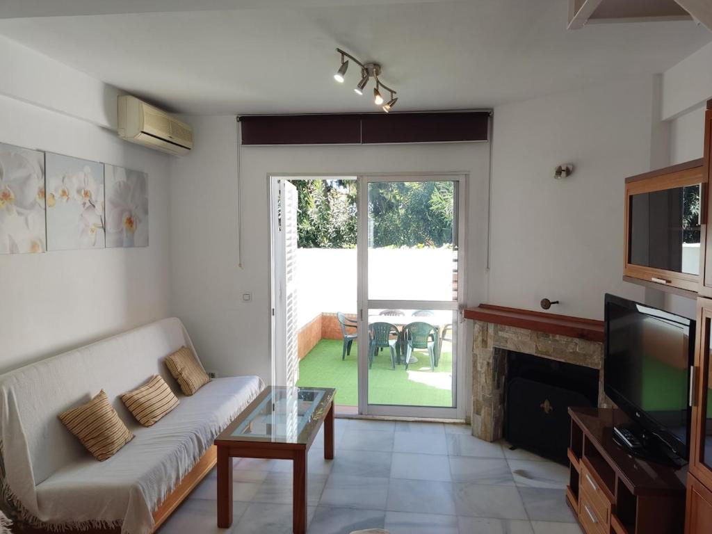 a living room with a couch and a tv at Mi Rinconcito de El Manantial in El Puerto de Santa María