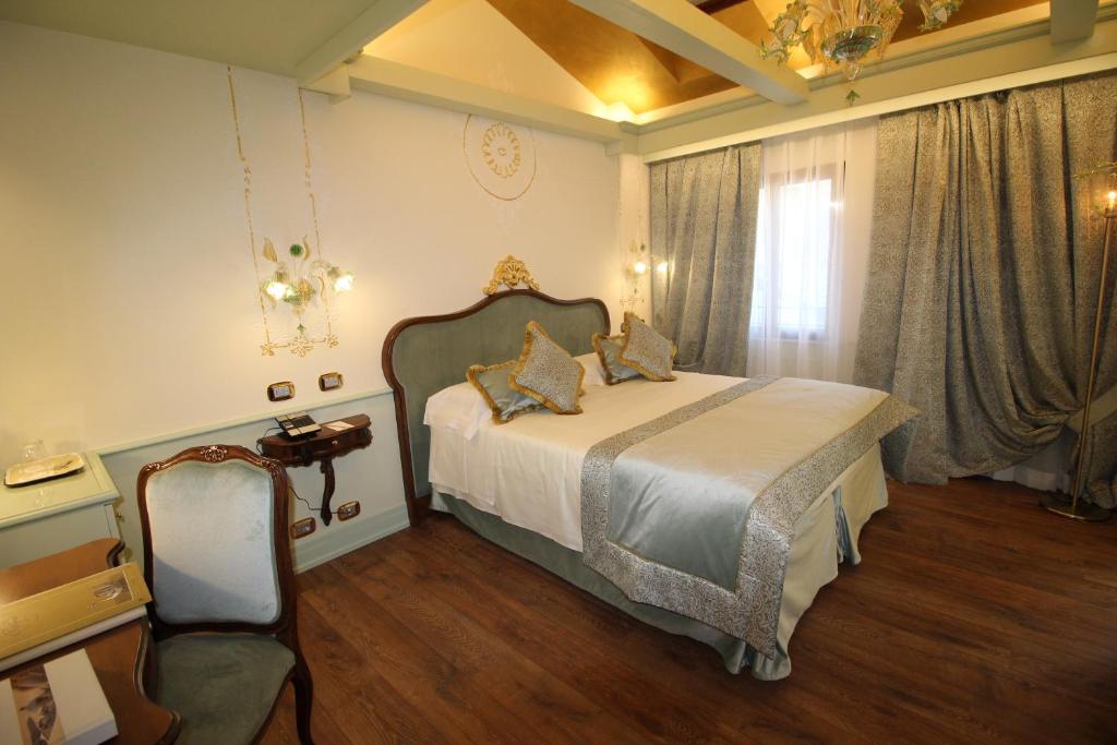 a bedroom with a bed and a chair and a window at Monaco &amp; Grand Canal in Venice