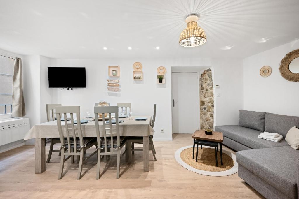 une salle à manger et un salon avec une table et des chaises dans l'établissement Le Nid Mediterranean, Cosy 3 rooms, à Menton