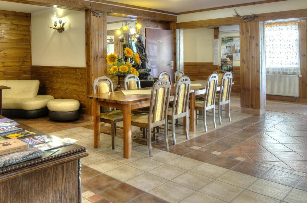 Dining area with wooden table, chairs, and decorative sunflowers.