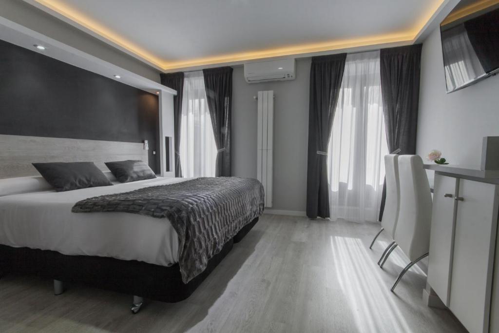 1 dormitorio con 1 cama grande y algunas ventanas en Hostal Overnight Madrid, en Madrid