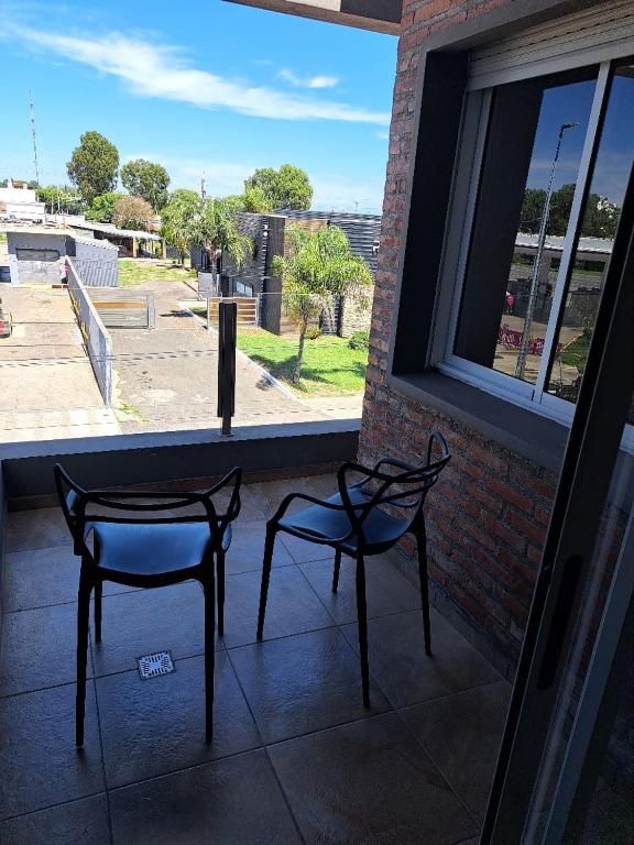 two chairs sitting in front of a window at Departamentos 1943-2 in Villa Constitución