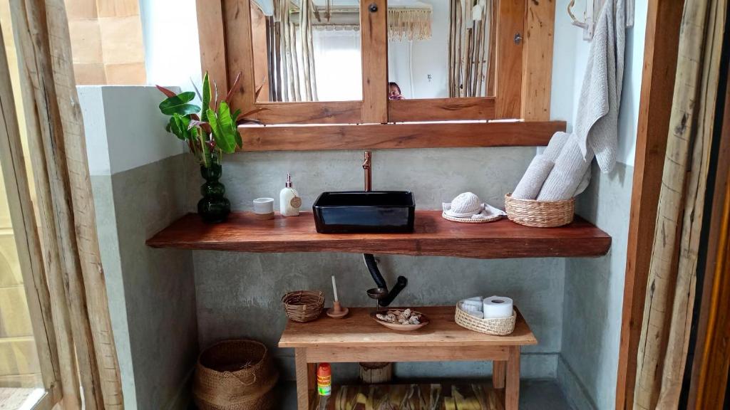 La salle de bains est pourvue d'une étagère en bois et d'un lavabo. dans l'établissement Casa Kaûma - Suíte Mar, à Corumbau
