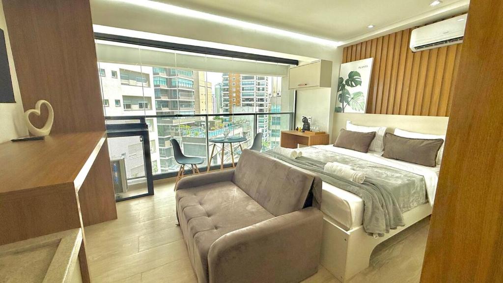 a bedroom with a bed and a couch and a window at 1201 - Rentaqui Moema Comfort Windon in Sao Paulo