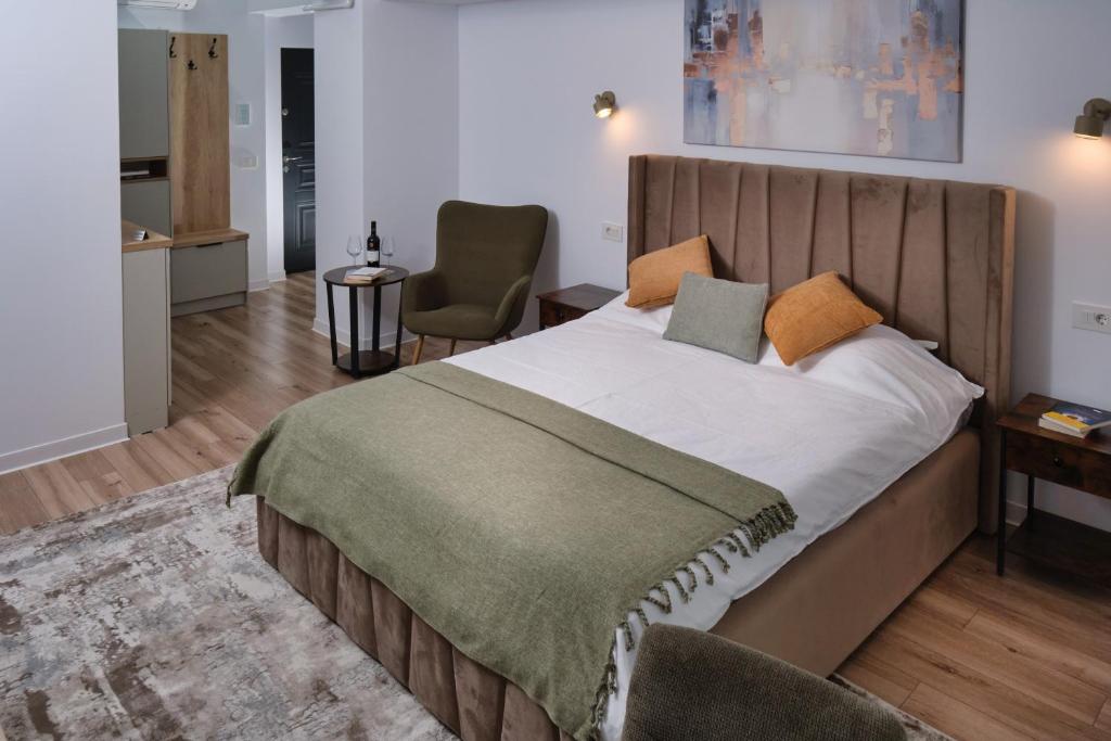 a bedroom with a large bed and a chair at Chill & Cozy in Valea Lupului