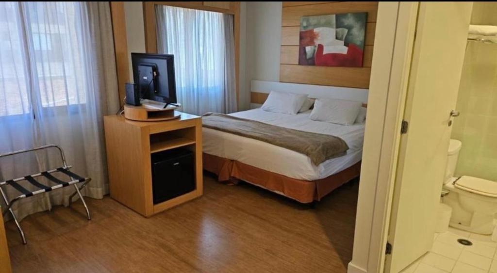 a bedroom with a bed and a tv on a table at Flat Hotel Aeroporto Congonhas UH1109 in São Paulo