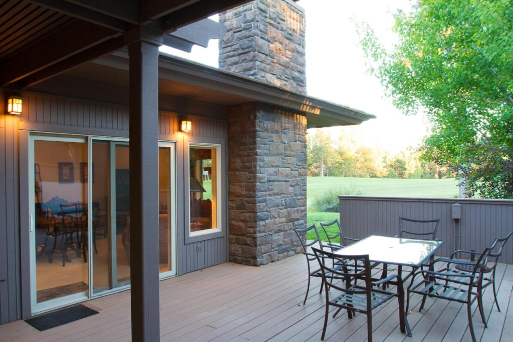a patio with a table and chairs on a deck at Villa #5 at Broken Top in Bend