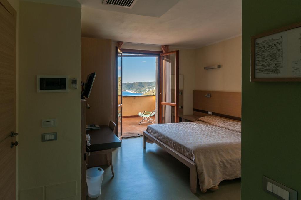 a bedroom with a bed and a door to a balcony at Oroverde in Bergeggi