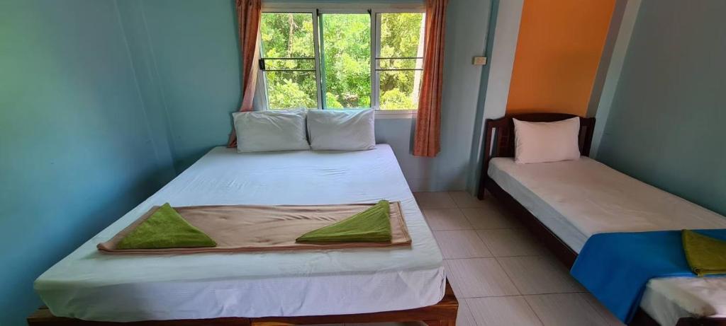 Postel nebo postele na pokoji v ubytování Sarin Guesthouse สาริน