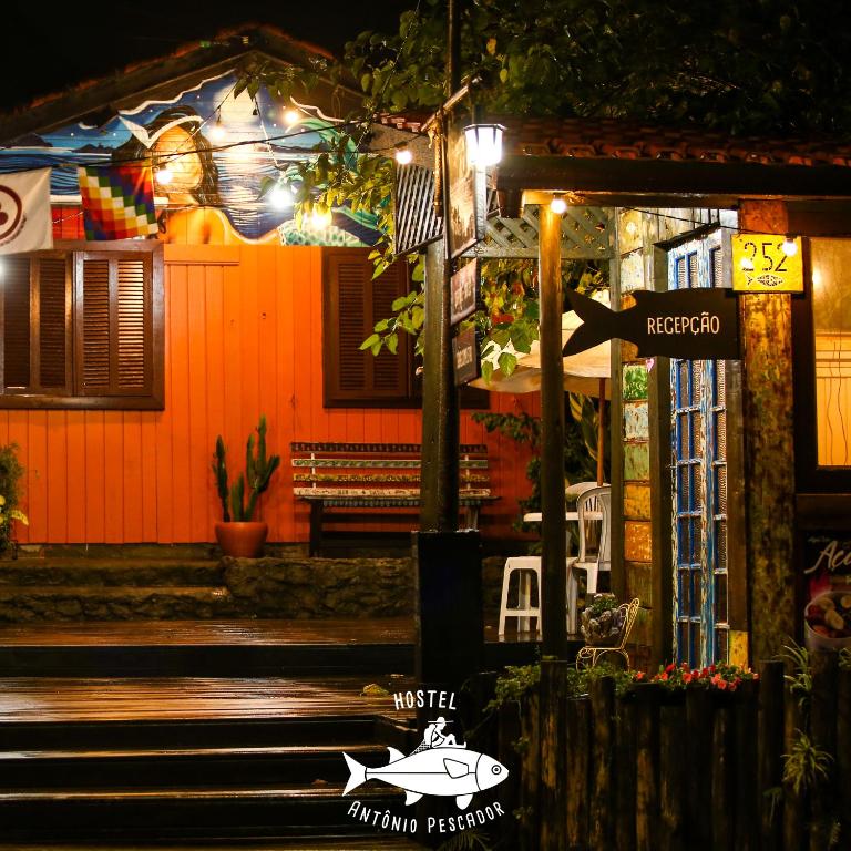 a street sign in front of a house at night at Hostel Antônio Pescador - Centro da Guarda do Embaú in Guarda do Embaú