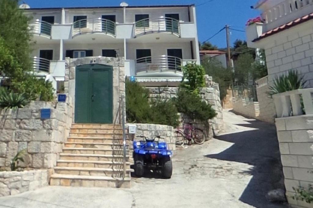 a blue motorcycle parked in front of a house at Seaside secluded apartments Drvenik Veliki, Drvenik - 23892 in Veliki Drvenik