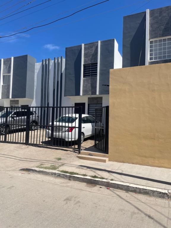 una macchina bianca parcheggiata di fronte a un edificio di Departamento Mazatlan a Mazatlán