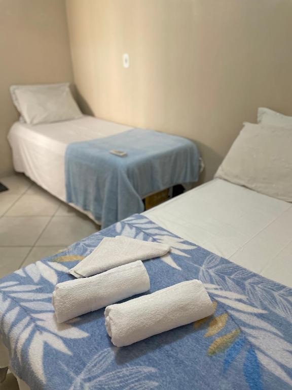 two beds in a room with towels on them at Kitnets Prático Aconchego in Petrolina