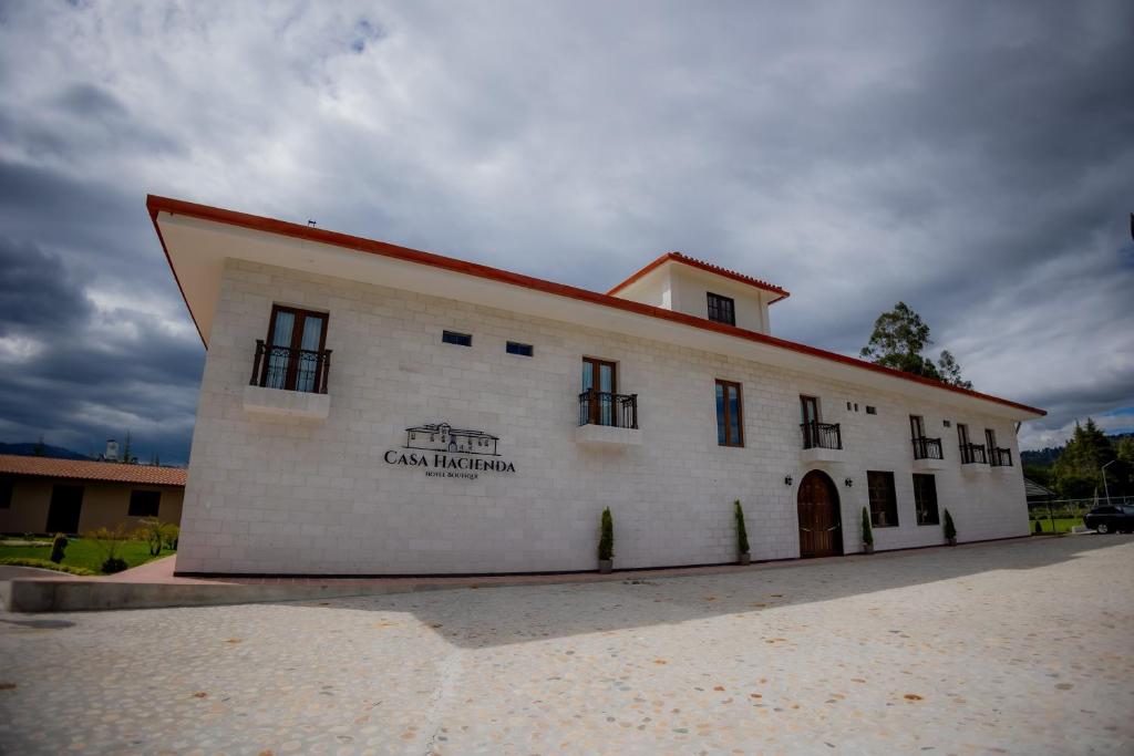 a large white building with a red roof at Casa Hacienda Hotel Boutique in Cajamarca
