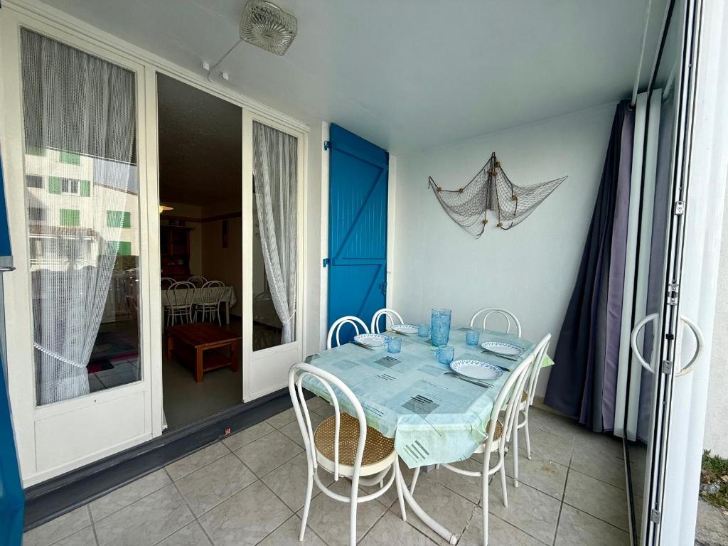 une table bleue et des chaises sur un balcon avec une table et des chaises dans l'établissement APPARTEMENT AVEC TERRASSE PROCHE PLAGE - FR-1-652-49, à Saint-Hilaire-de-Riez