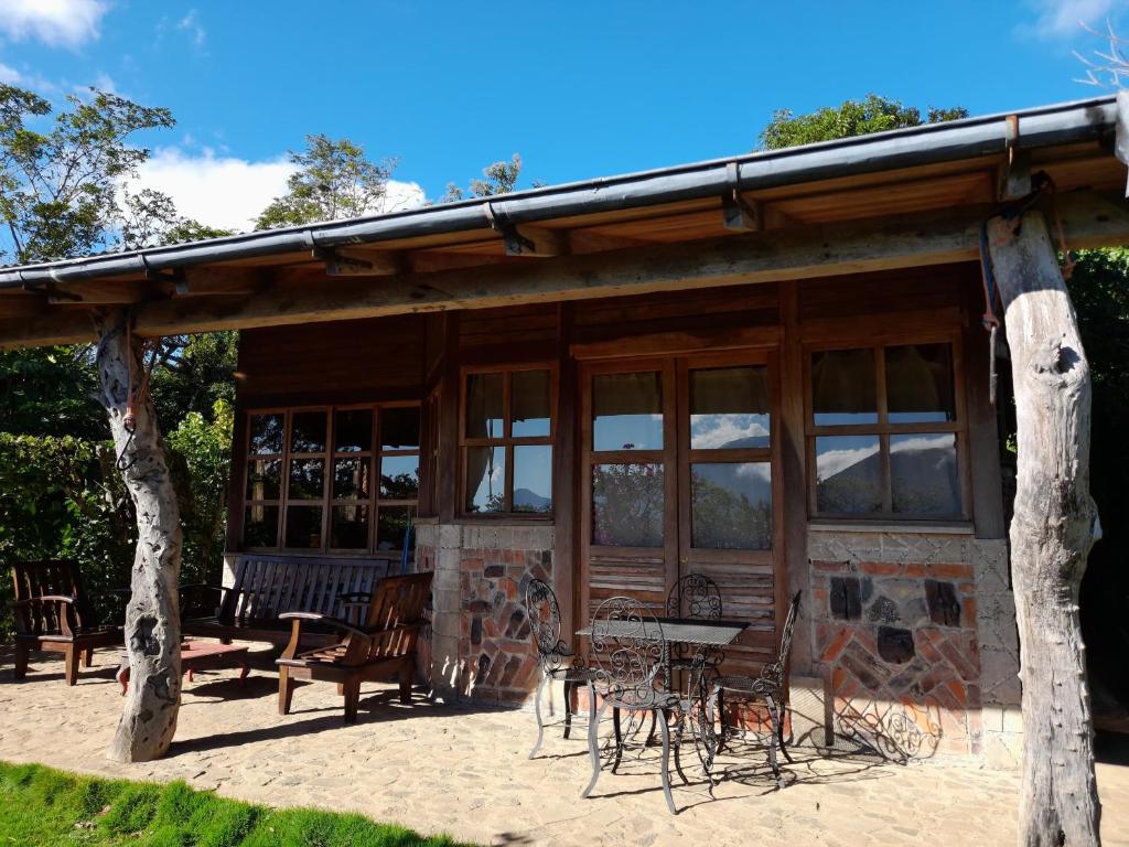 a building with a table and chairs in front of it at cabaña Lechuza café in Juayúa