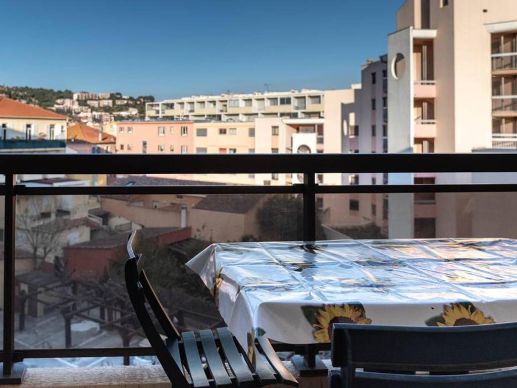 une table et des chaises sur un balcon avec vue sur une ville dans l'établissement T2 + cabine au Lavandou, proche plage, climatisation, parking privé - FR-1-803-19, au Lavandou