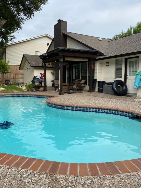 a swimming pool in front of a house at The Ultimate Staycation in San Antonio