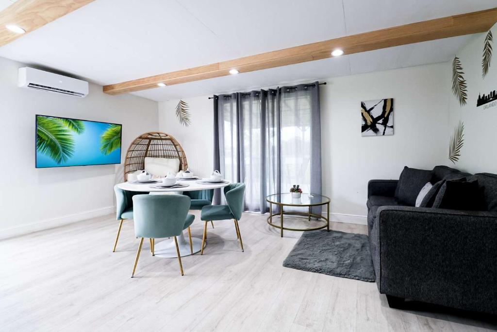 a living room with a table and chairs and a couch at BRANDNEW 2023 LAKEFRONT APT in Kissimmee