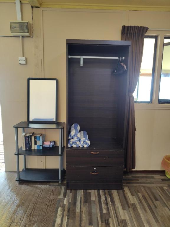 a black dresser with a mirror and a shelf at Permata Beach Chalet in Kampong Juara