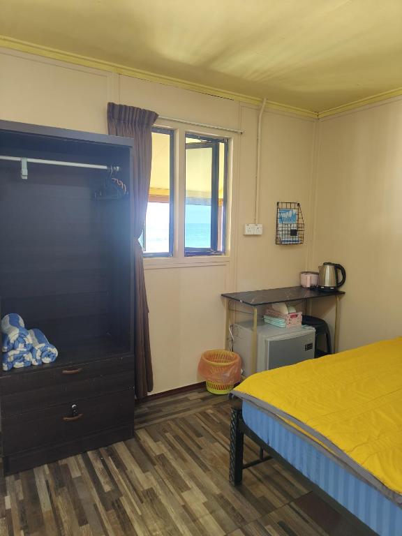 a bedroom with a bed and a window at Permata Beach Chalet in Kampong Juara