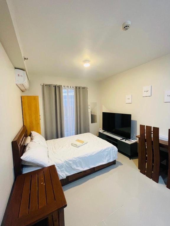 a bedroom with a bed and a desk and a television at Jack Cabin in Lapu Lapu City