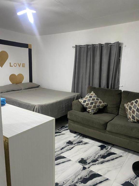 a living room with a couch and a bed at White Room Sparks in Spanish Town