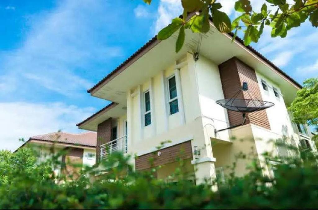 a white house with a gambrel roof at Near airport cozy home in Chiang Mai