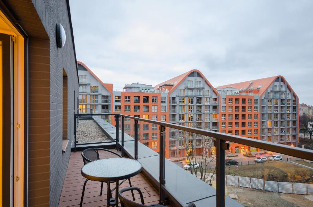 balkon ze stołami, krzesłami i budynkami w obiekcie Dom & House - Apartments Chmielna Park w Gdańsku