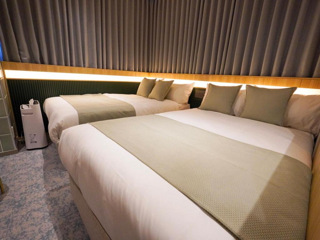 Postel nebo postele na pokoji v ubytování The GALA Hotel Umeda