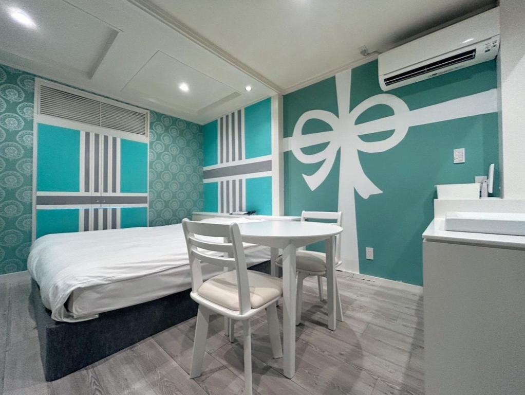 a bedroom with a bed and a table and chairs at ホテルフローレスツーadultonly in Tsubame