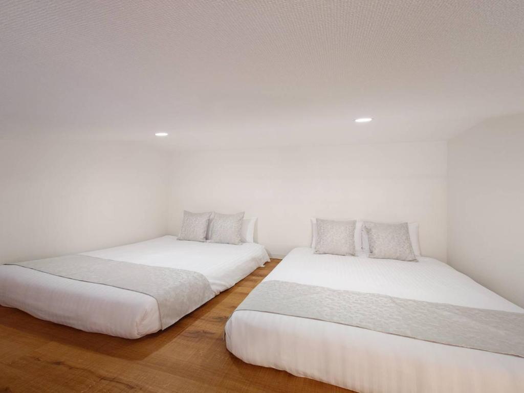 Postel nebo postele na pokoji v ubytování Neighbor's Hotel 五日市コイン通り